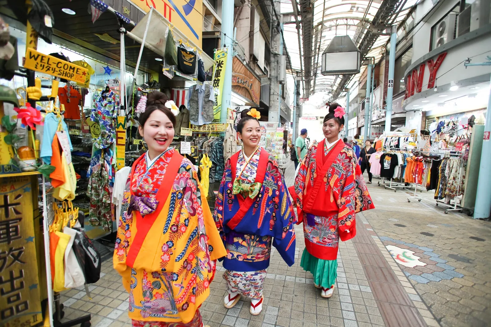 アーケード商店街を琉装で歩く女性3人
