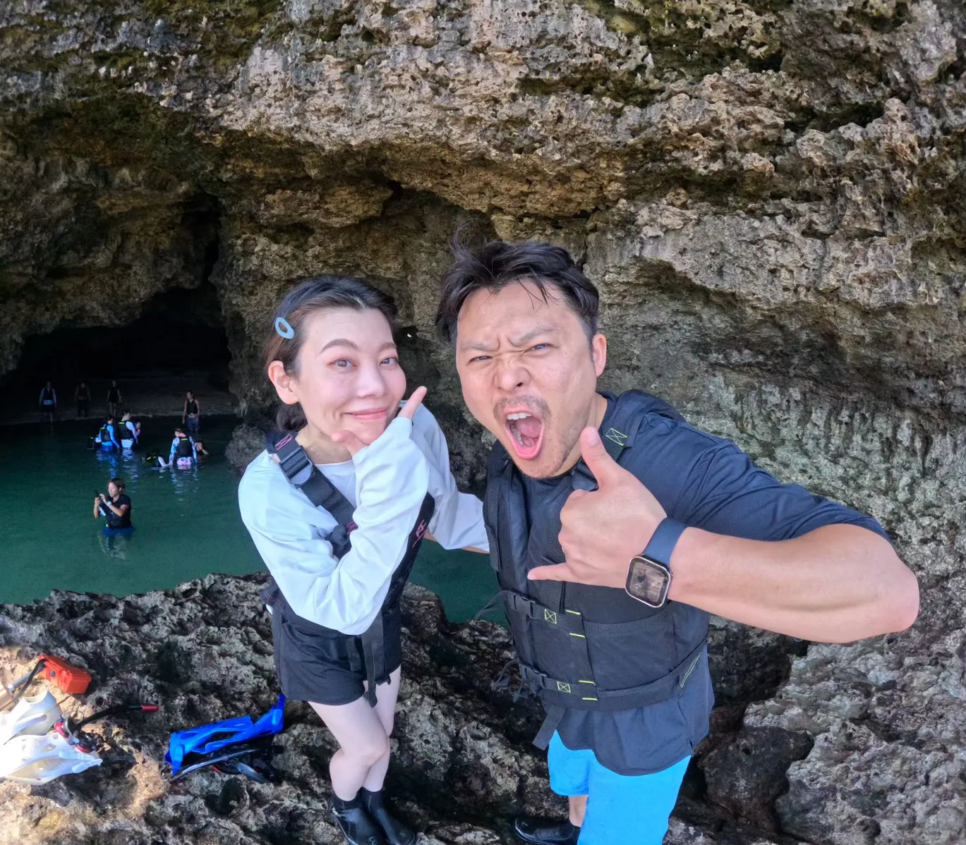 A man and woman in life jackets posing on the rocks of the Blue Cave
