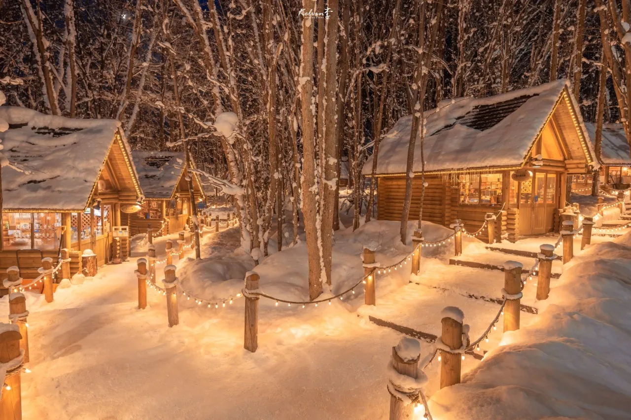雪に覆われたニングルテラスの小道と灯りのともる小屋