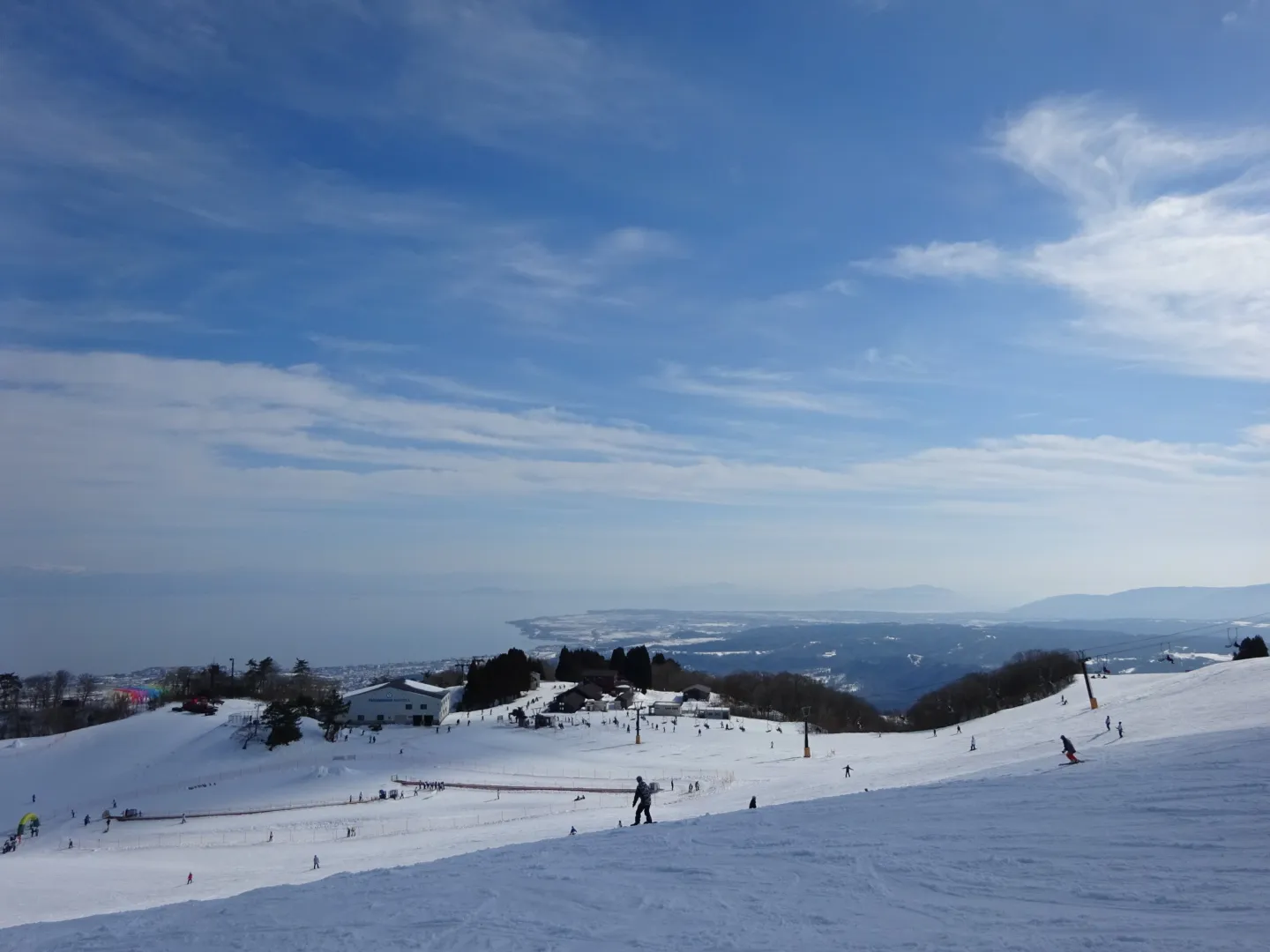 The snow-covered slopes of Mt. Hakodate Ski Resort, with Lake Biwa in the distance