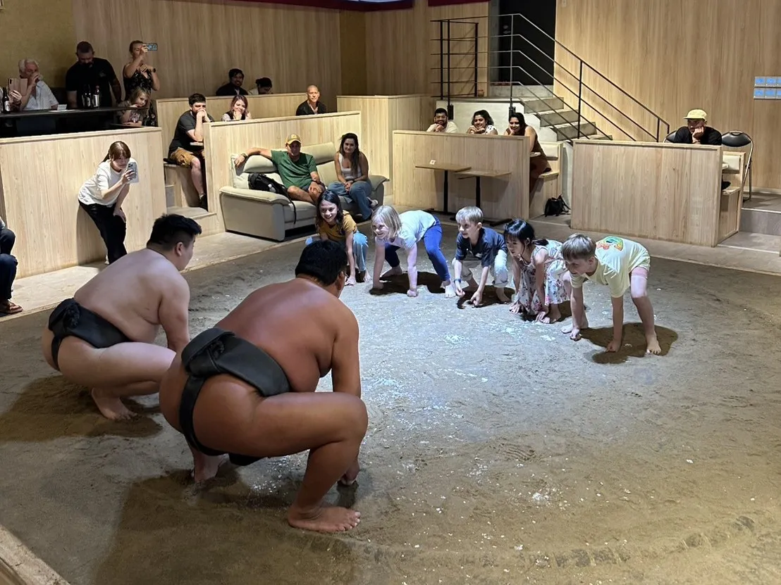 子どもたちが横一列に並び、二人の力士に向かって構える様子