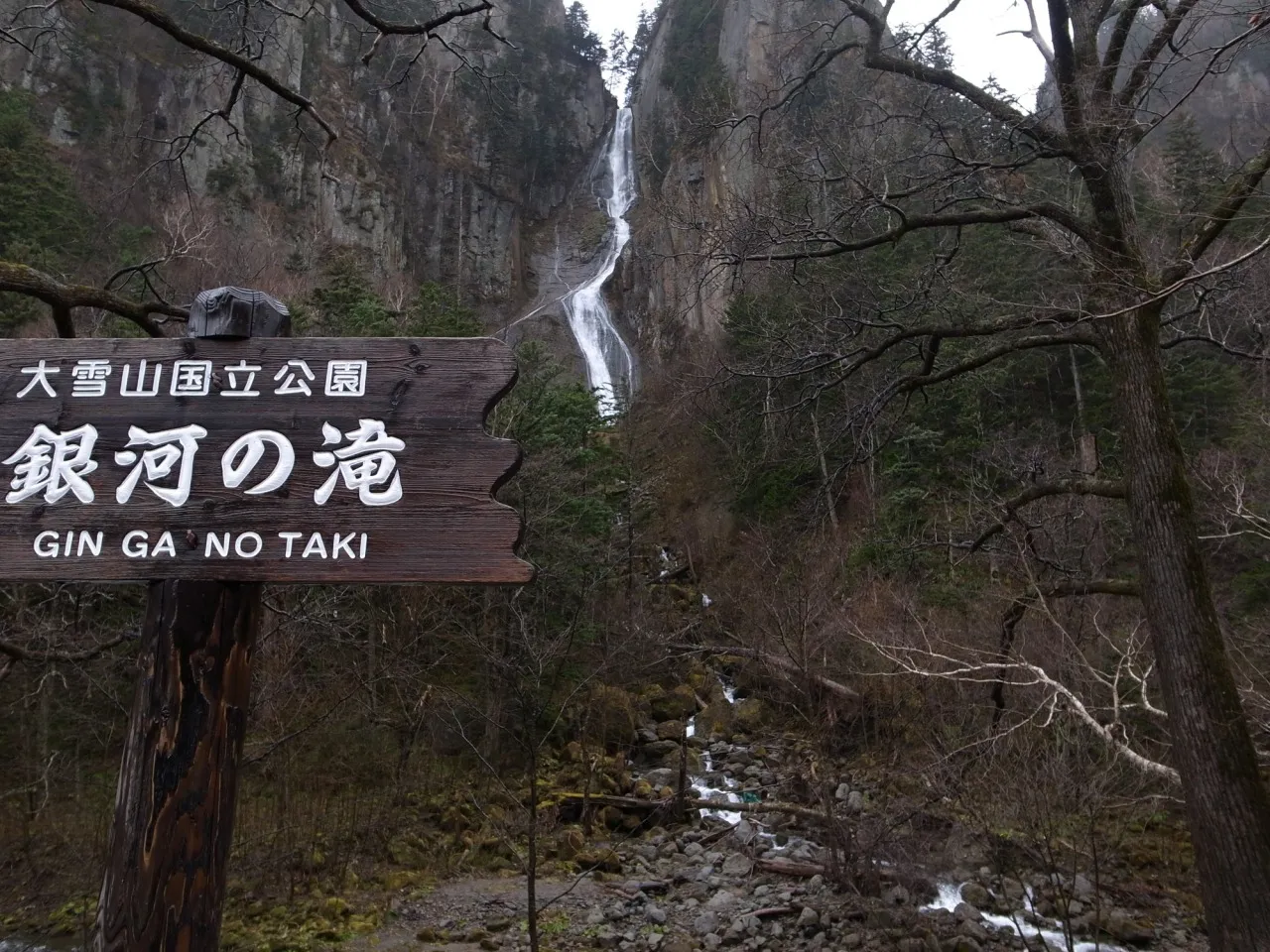 「銀河の滝」の看板と岩壁を流れ落ちる細い滝