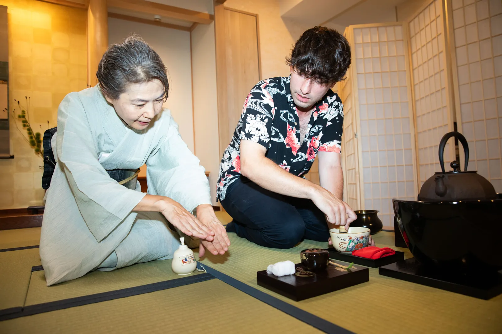 講師の手本を見ながら茶筅で抹茶を点てる参加者