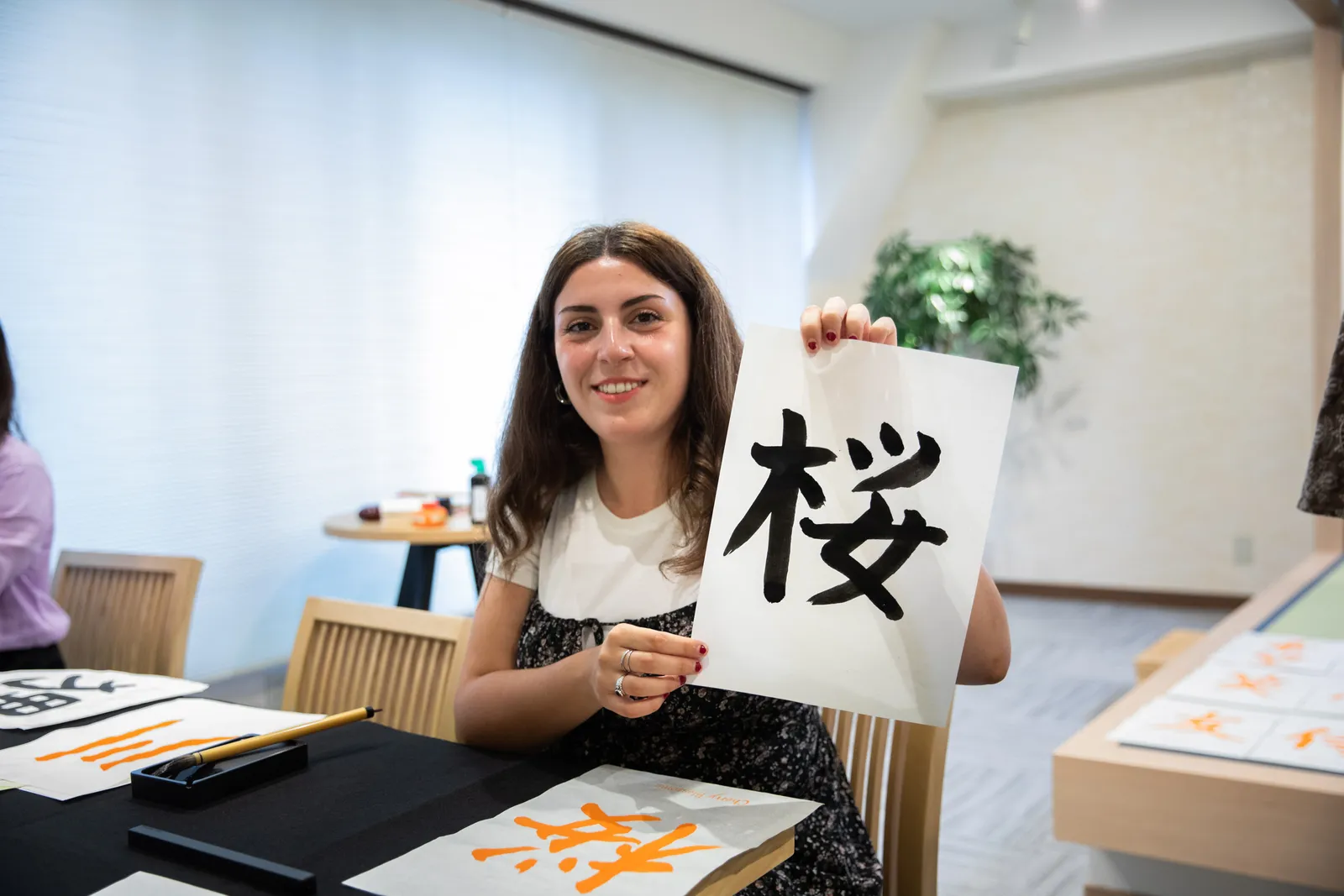 A participant holding up a piece with the character 桜 (cherry blossom)