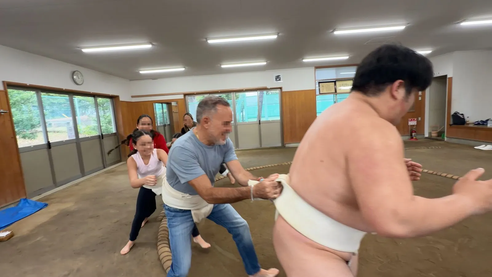A family group pushing together against the rikishi