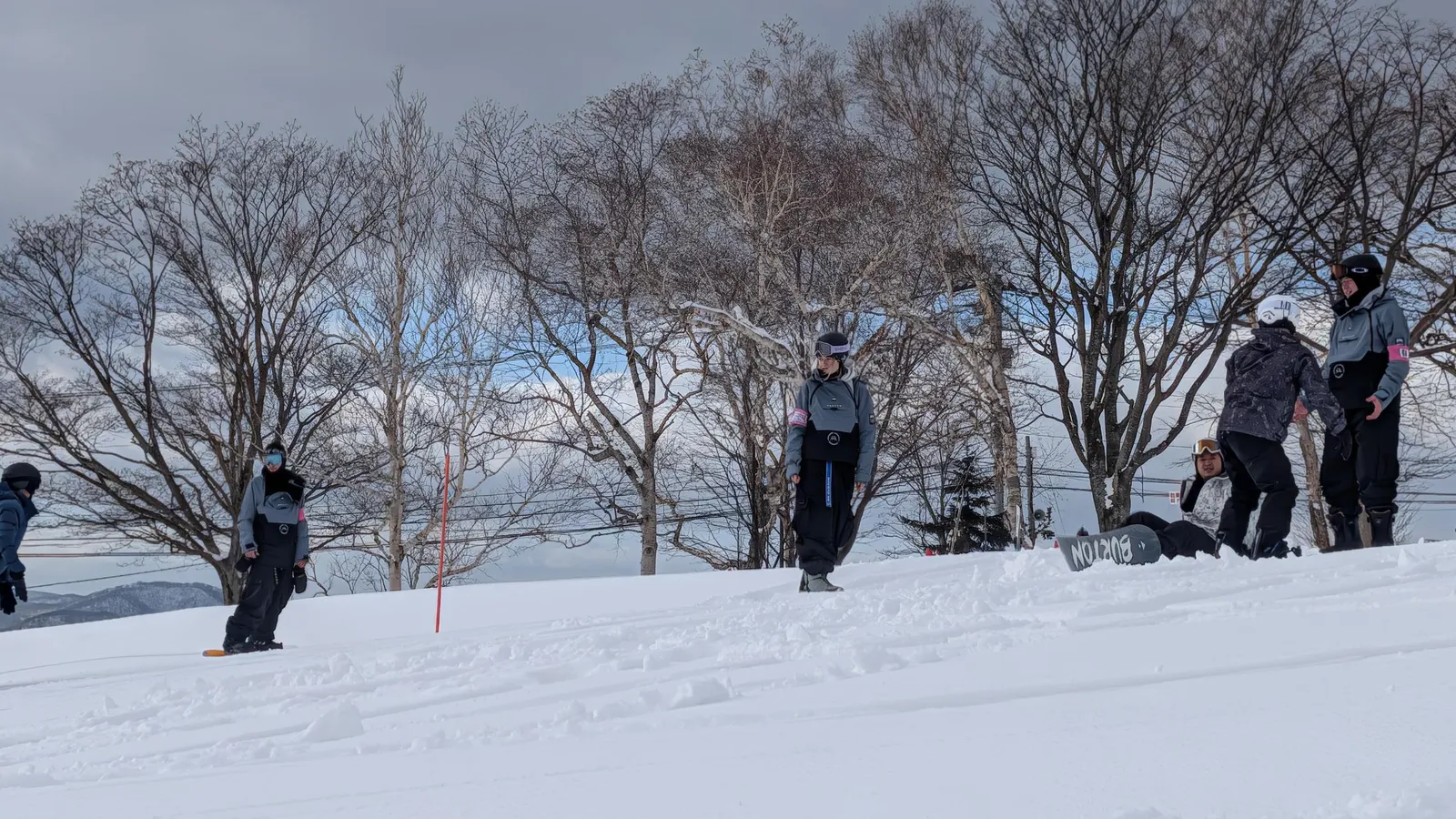 Participants practicing on a snowy slope, attaching their boards