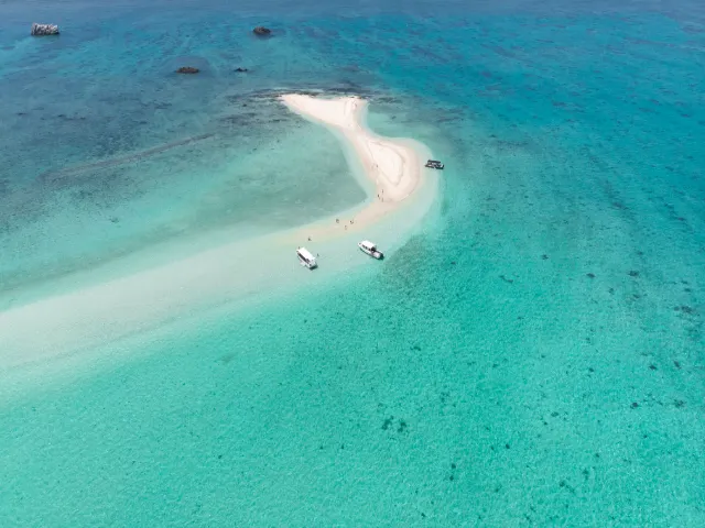 浜島の白い砂浜と周囲のボートを、上空から見た風景