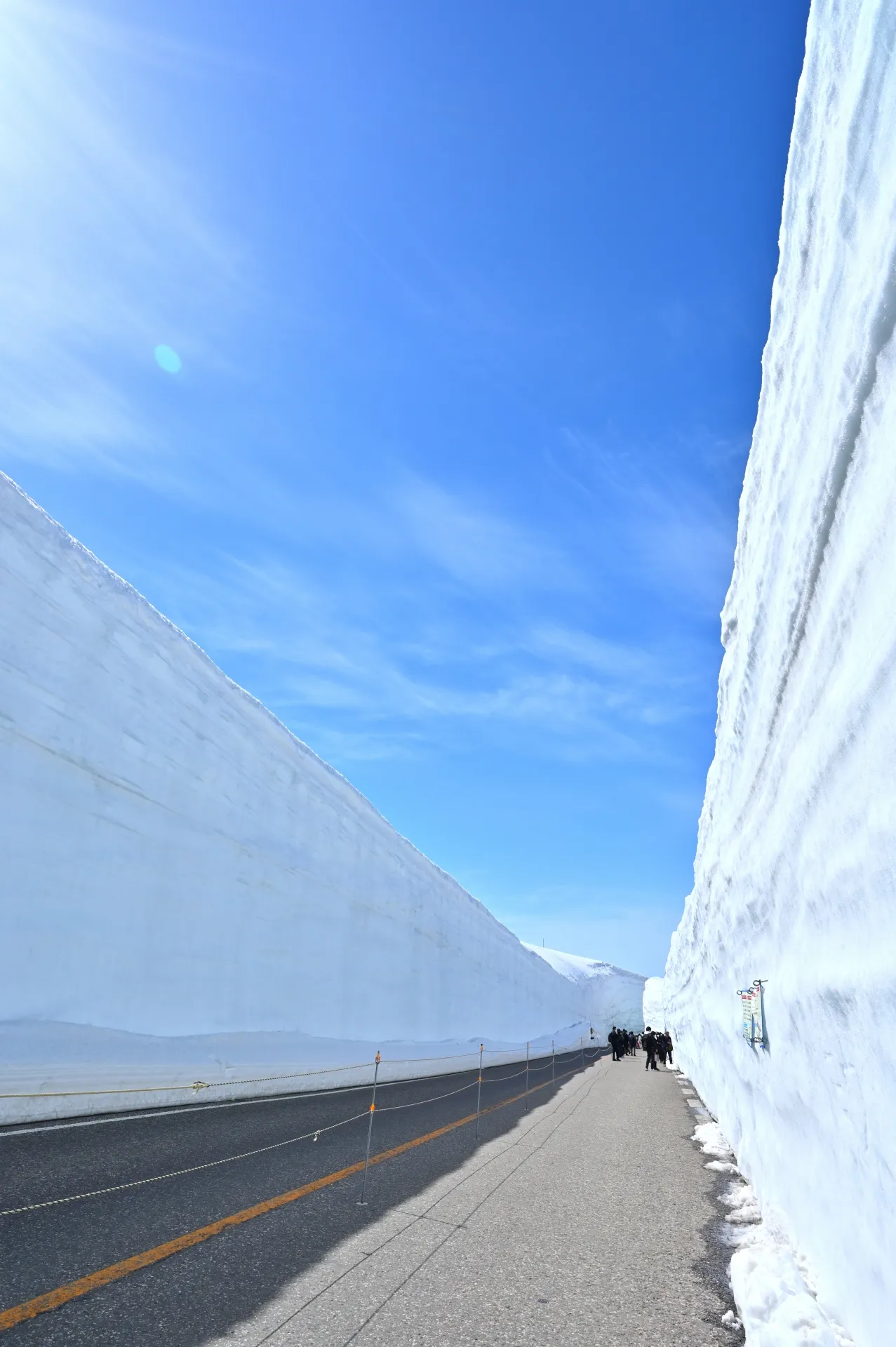 被高耸雪壁夹在中间的立山道路，以及其上方辽阔的蓝天