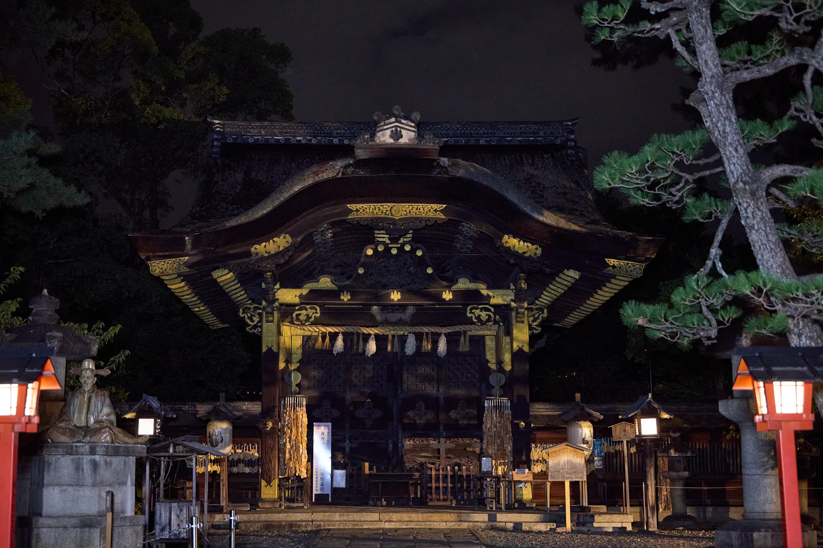 The Karamon gate of Toyokuni Shrine at night, flanked by red lanterns