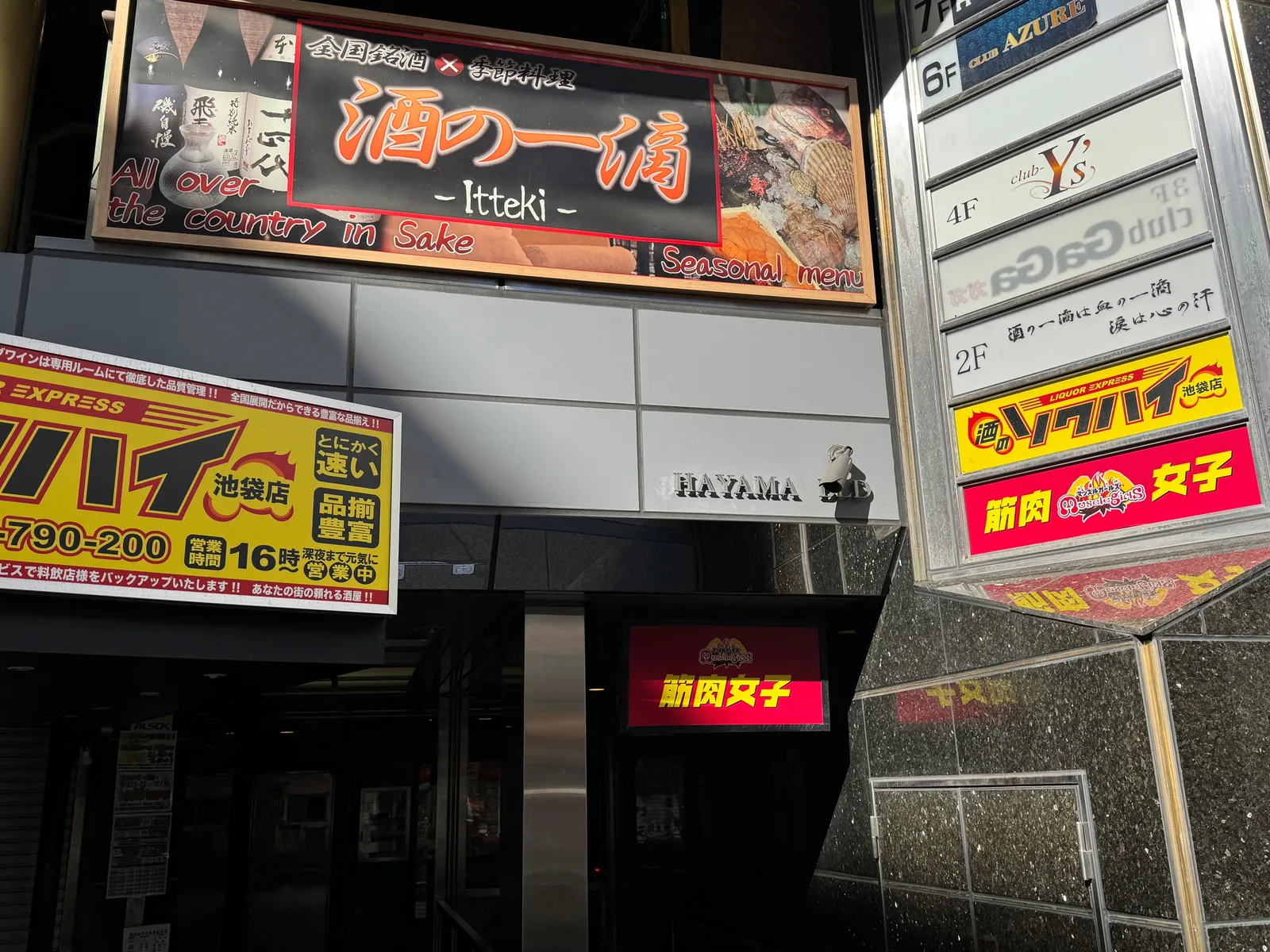The red "筋肉女子" (Kinniku Joshi) sign at the building entrance
