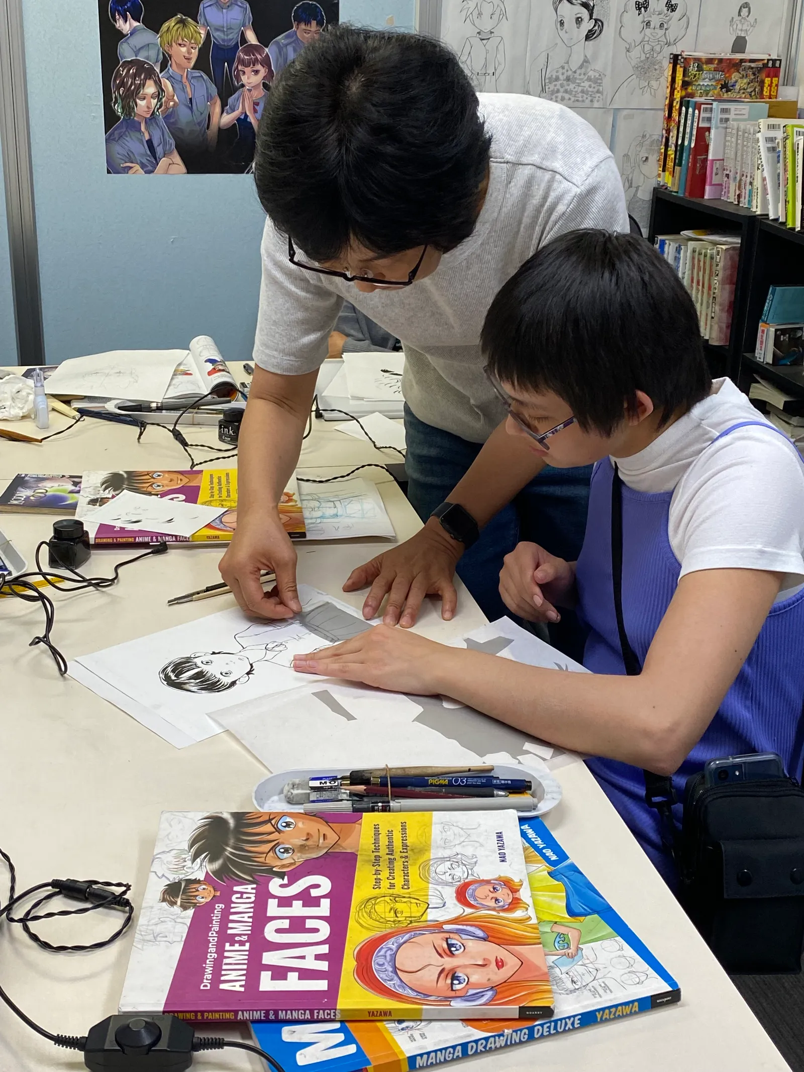 An instructor pointing at a participant's page while explaining