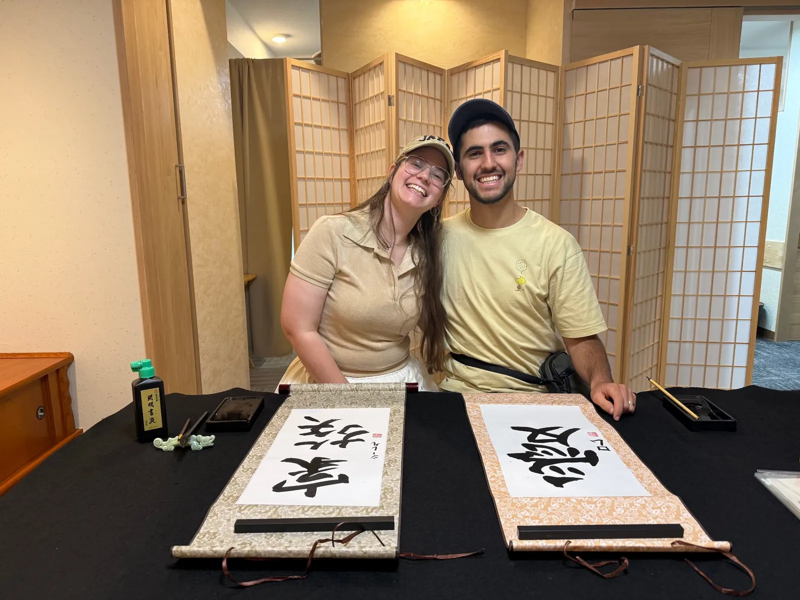 Two smiling people with their finished hanging scroll