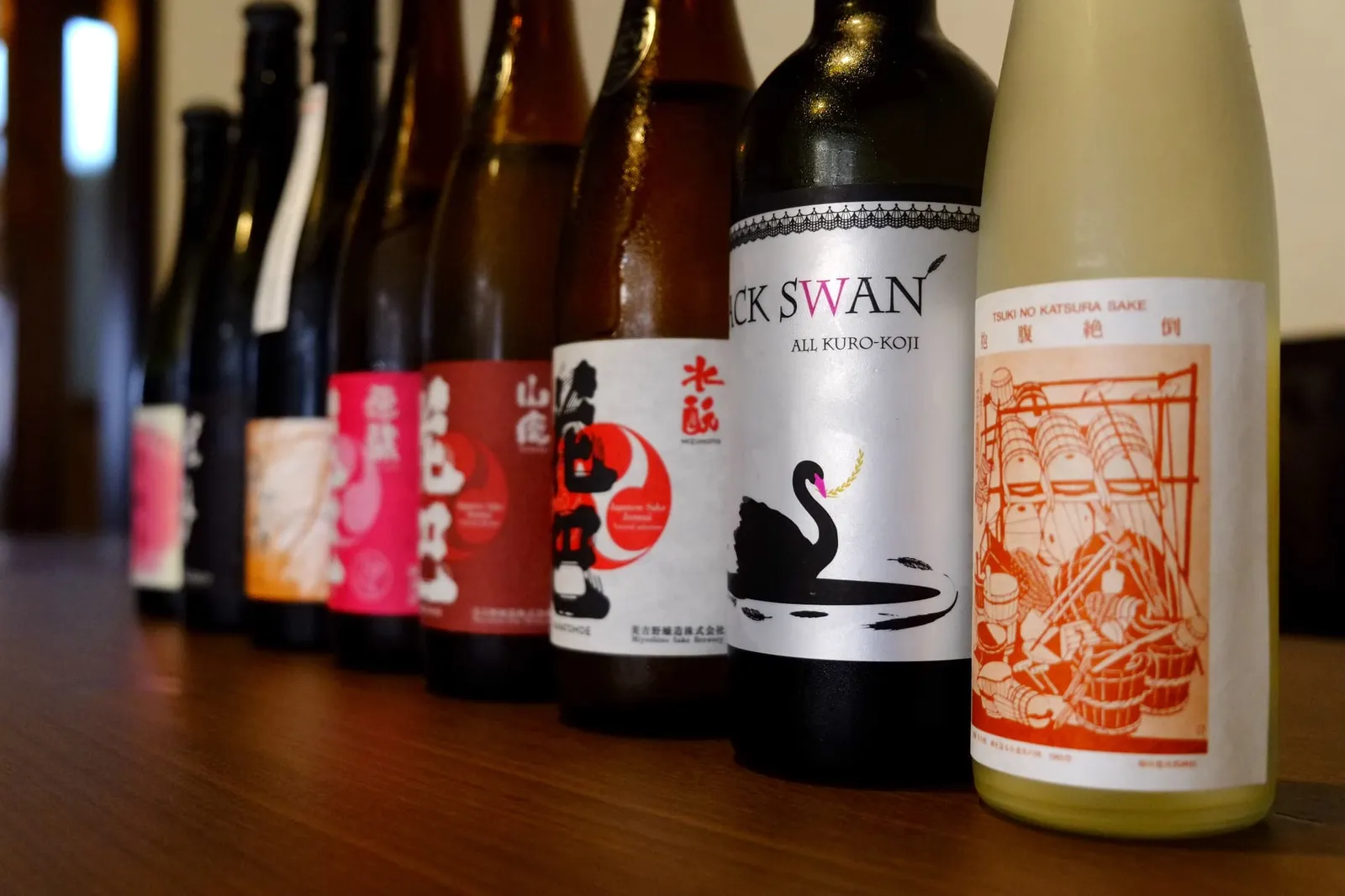 木のカウンターに並んだ日本酒のボトル