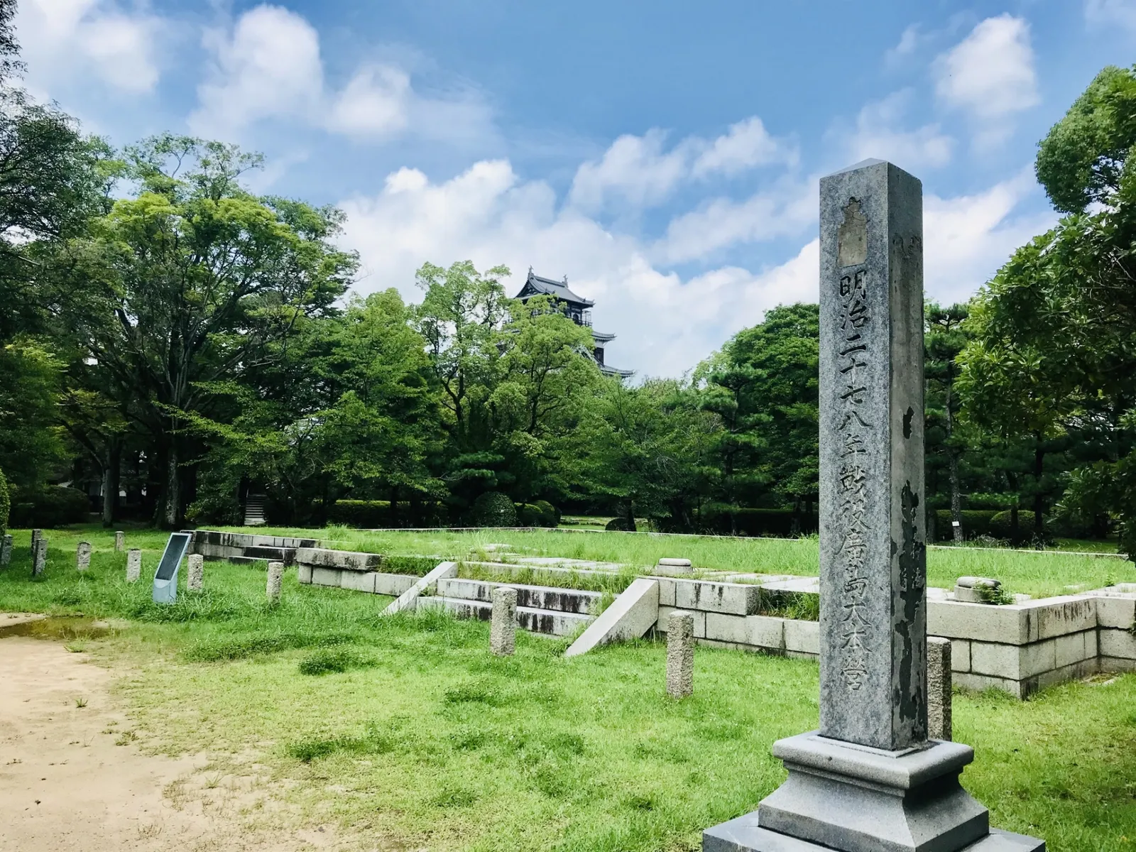 広島大本営跡の石碑と建物の土台、木々の奥に見える広島城天守