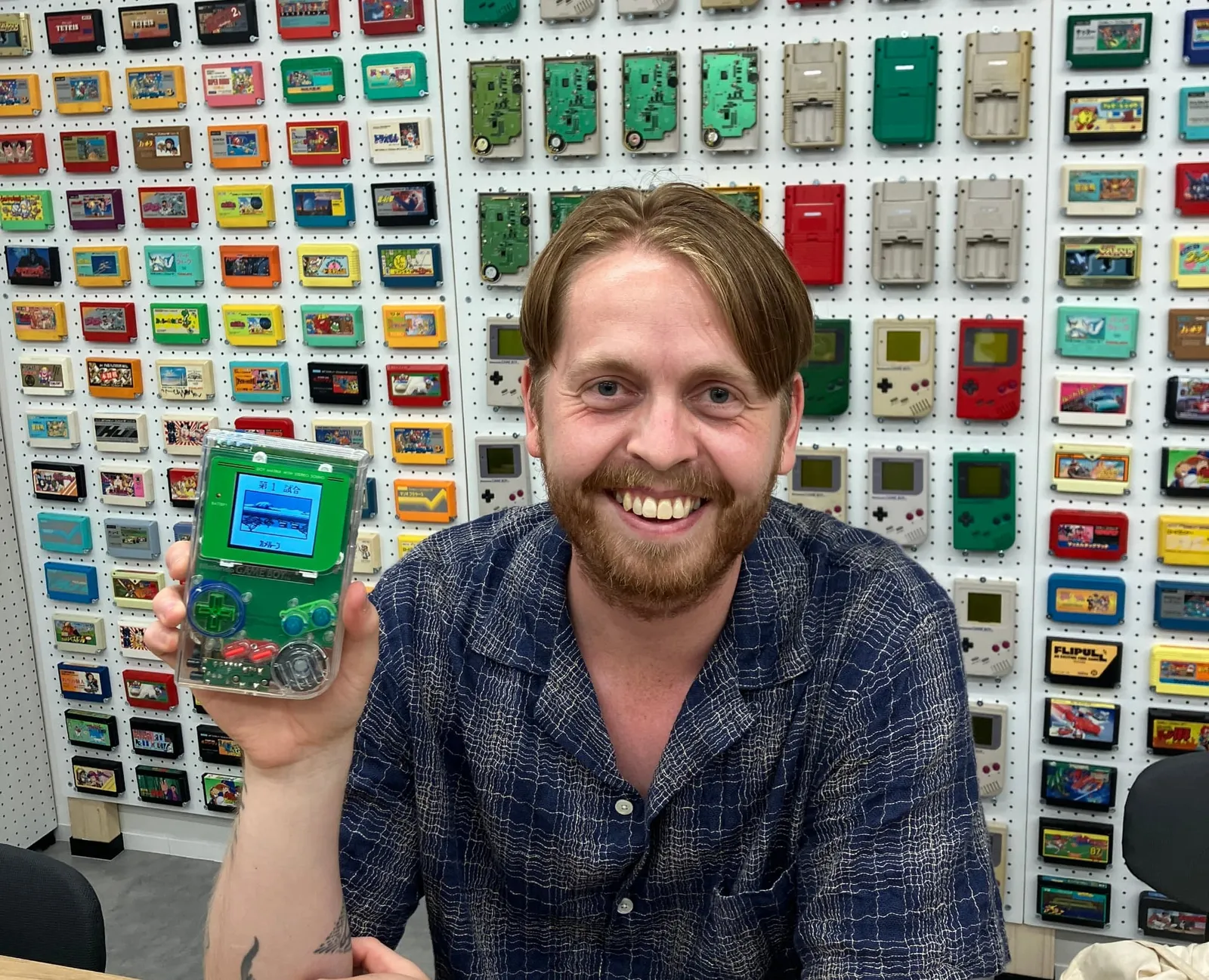 クリアシェルの完成したゲームボーイを掲げて笑う参加者