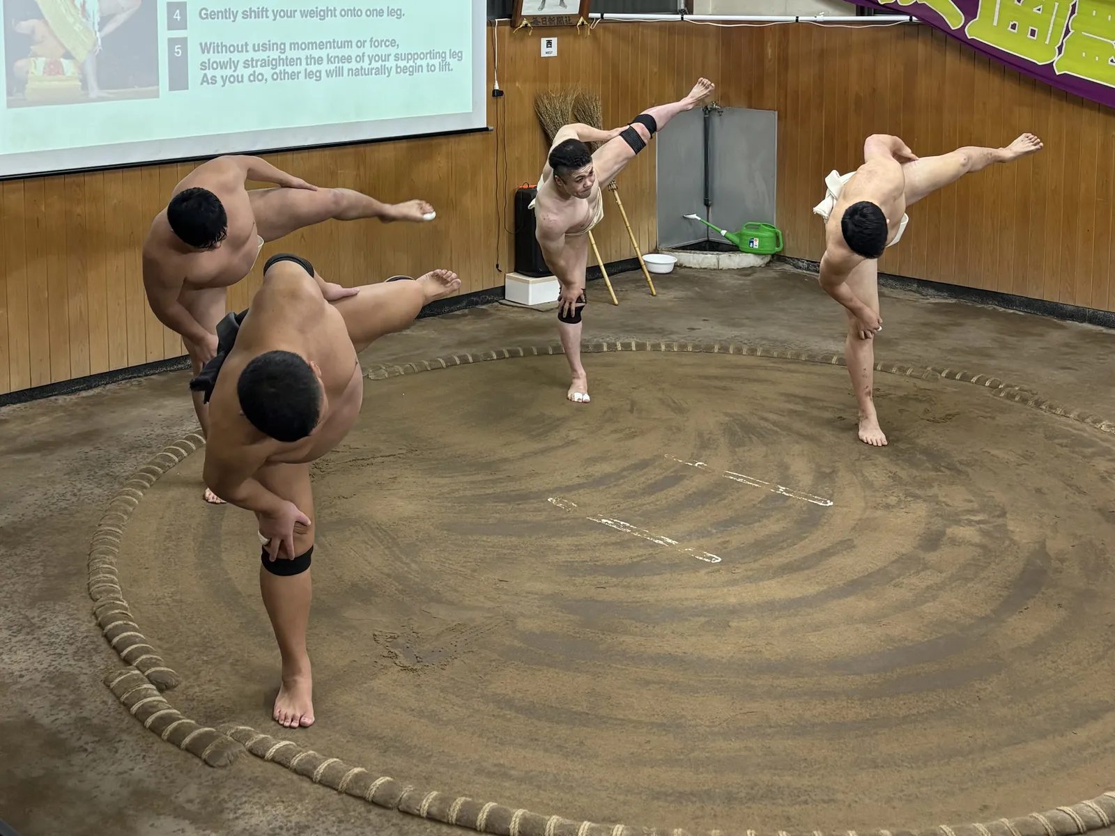 土俵で片足を上げて四股を踏む4人の元力士