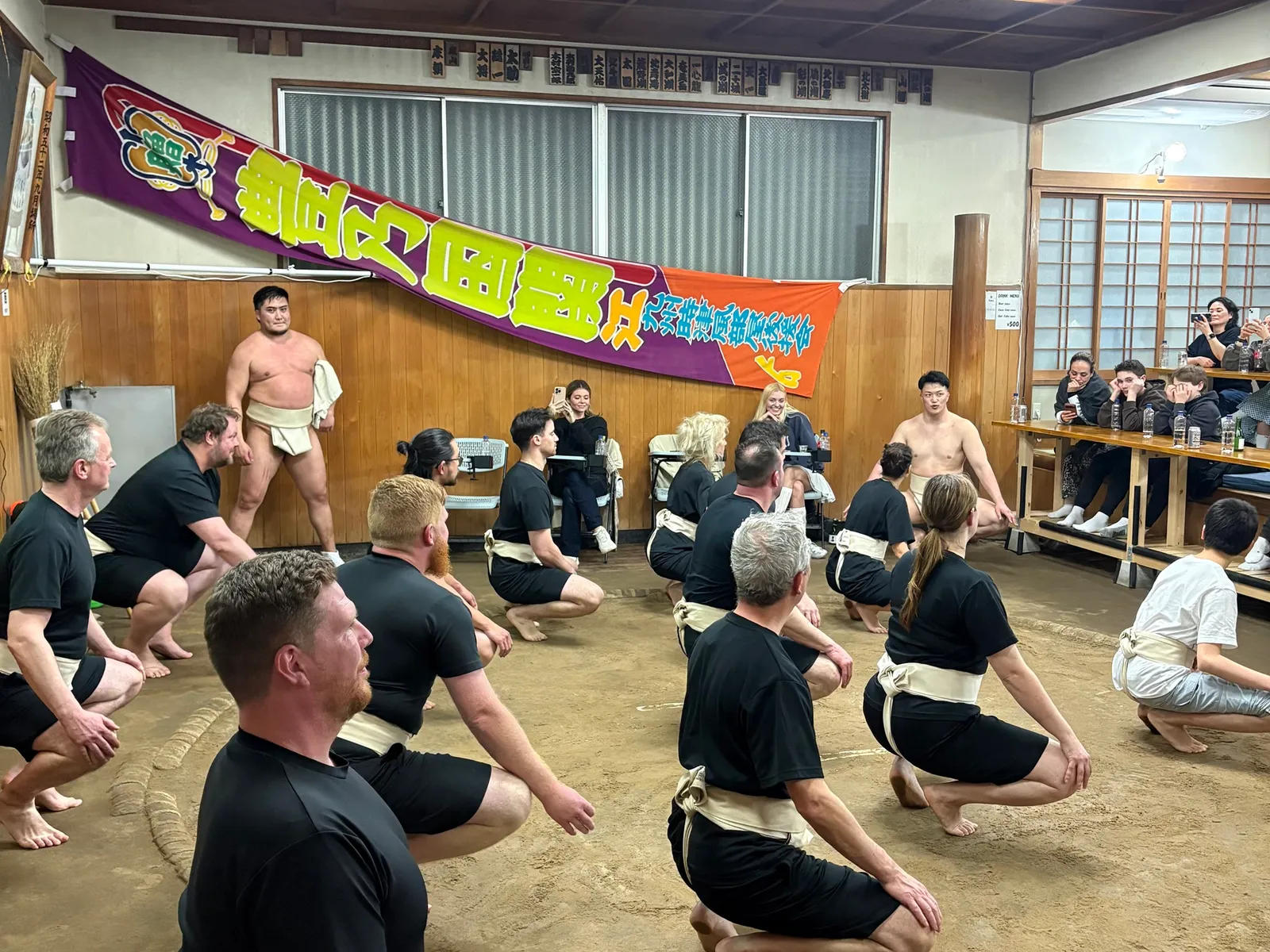 廻しを締めて蹲踞の姿勢をとる参加者