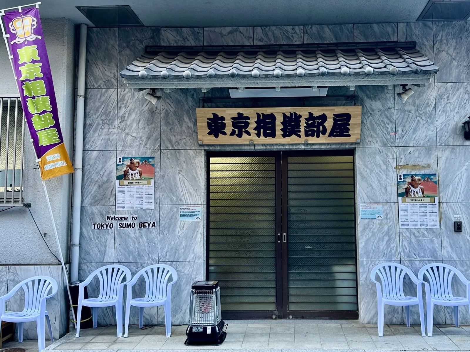 The entrance of Tokyo Sumo Beya, with its sign and purple banners