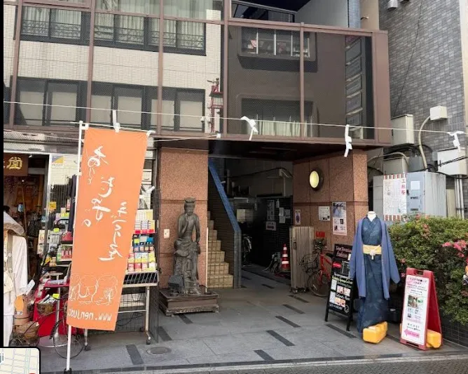 The building entrance with orange banners and a Buddha statue
