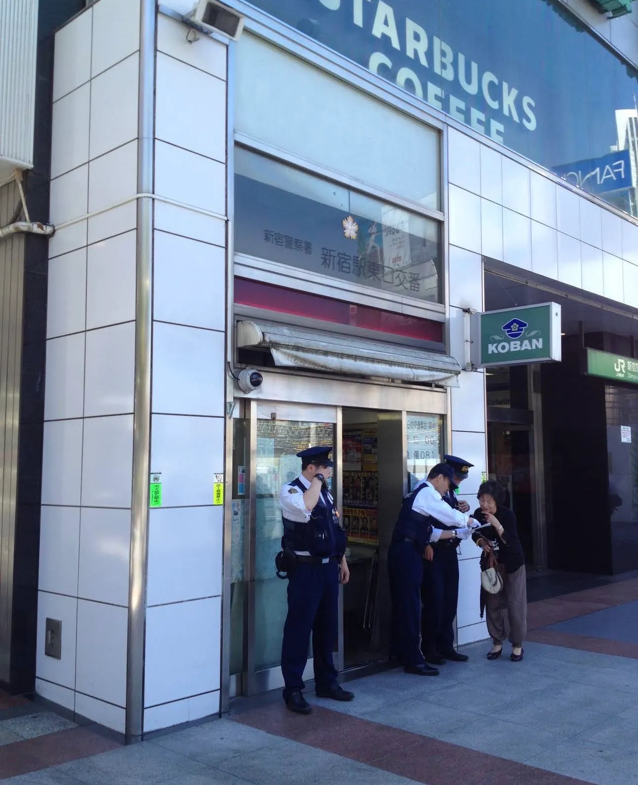 新宿駅東口交番の前に立つ警察官