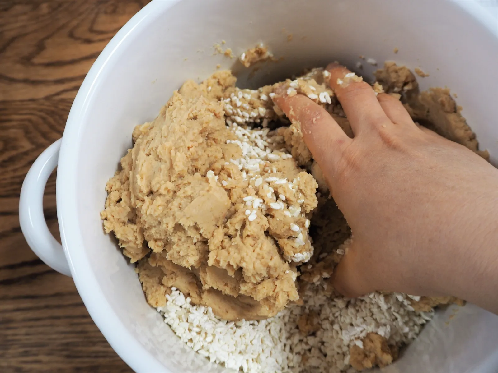容器の中で大豆と麹を手で混ぜる味噌作りの様子