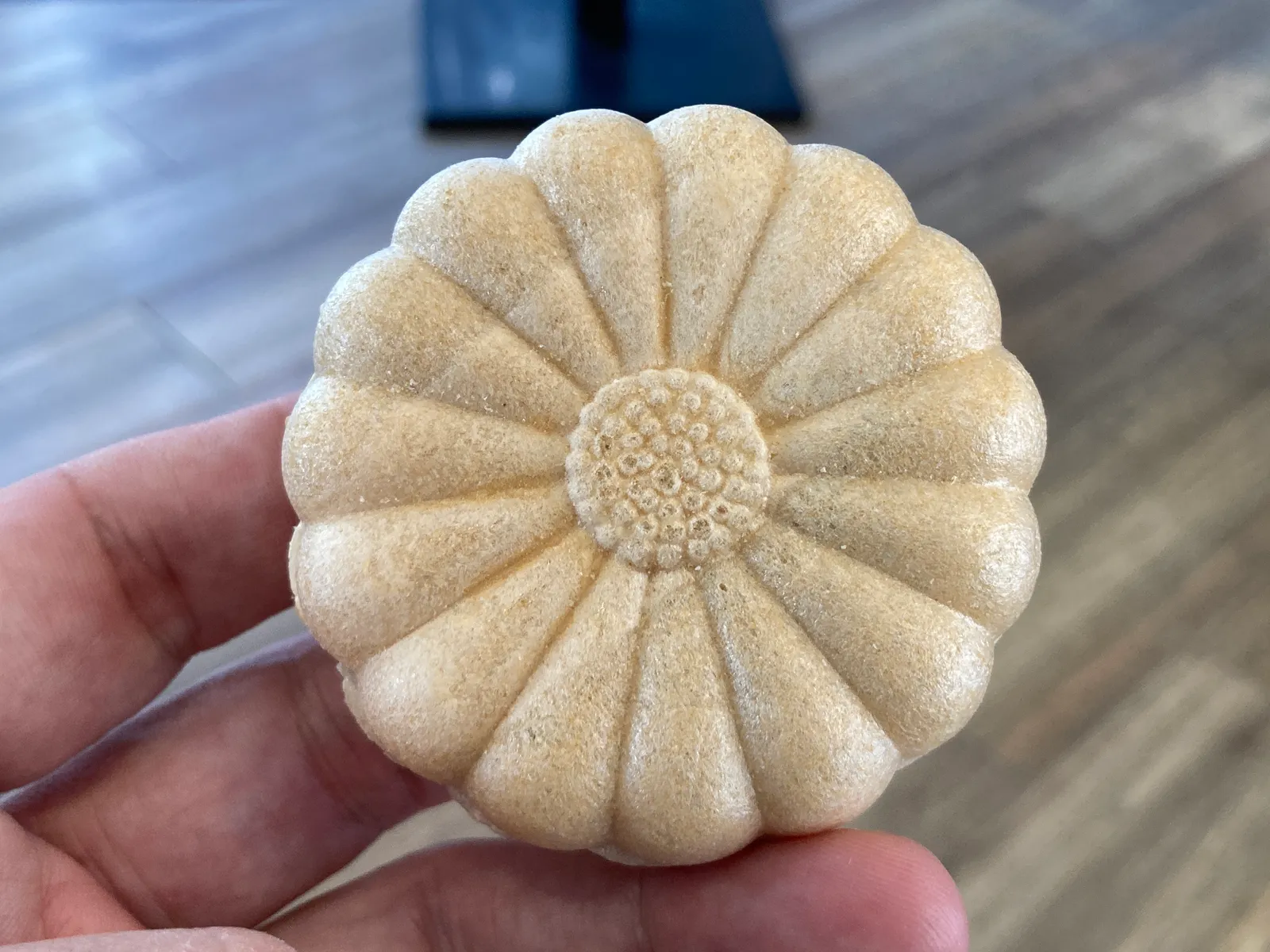 手のひらにのせた菊の花の形の焼菓子