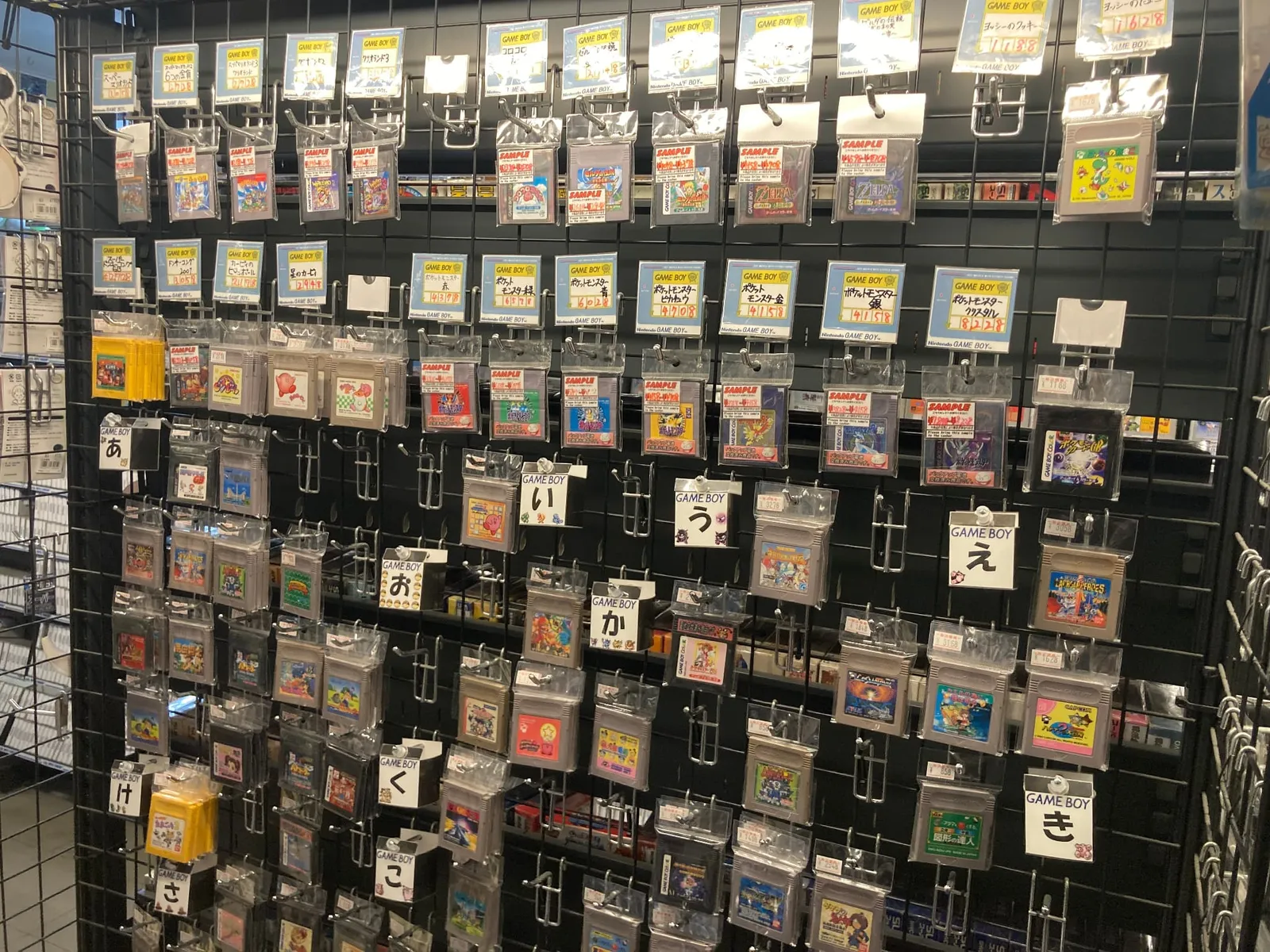 ゲームボーイのソフトが五十音順に壁面のフックへ吊るされた棚