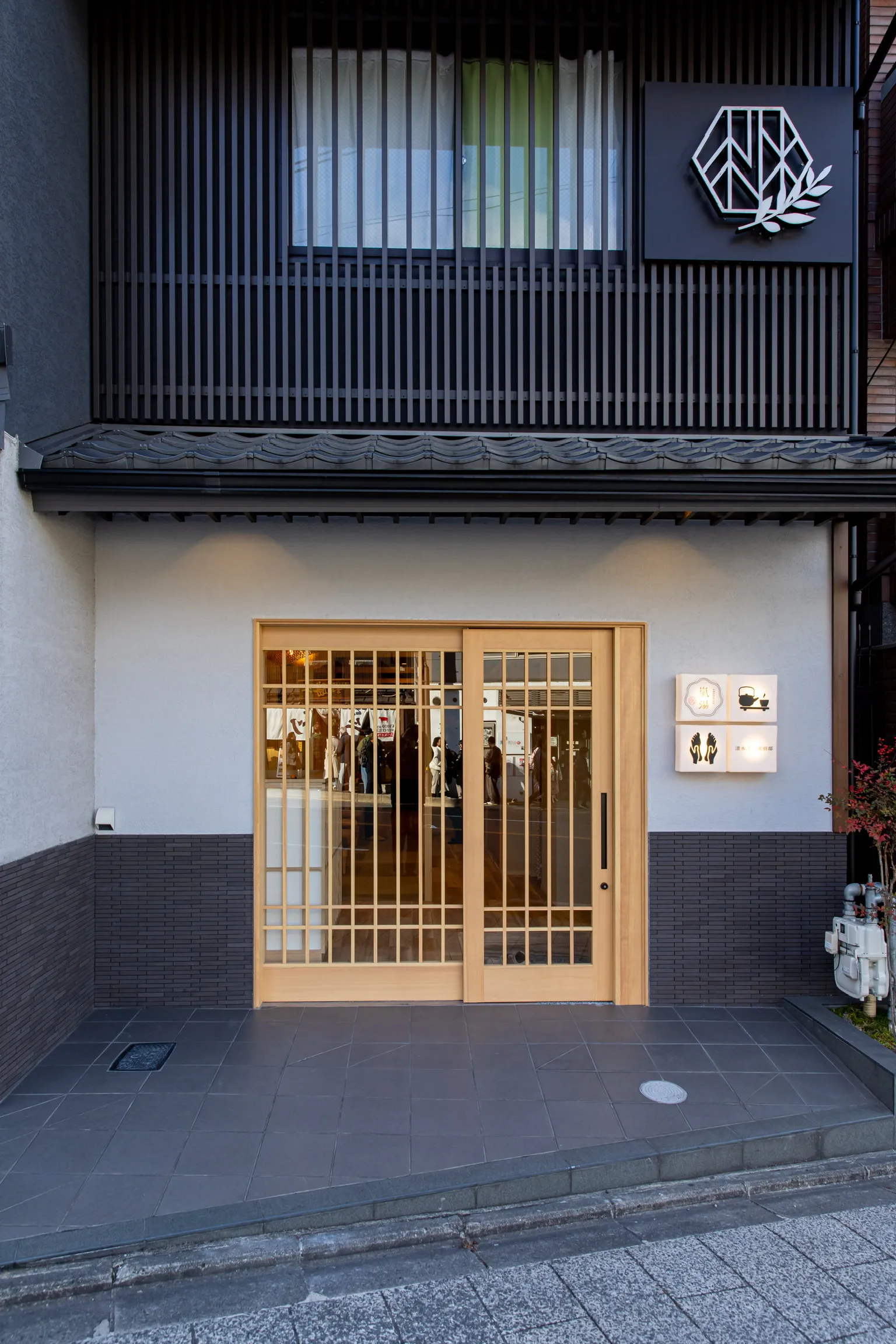 Exterior of a machiya-style shop with wooden lattice doors and tiled eaves