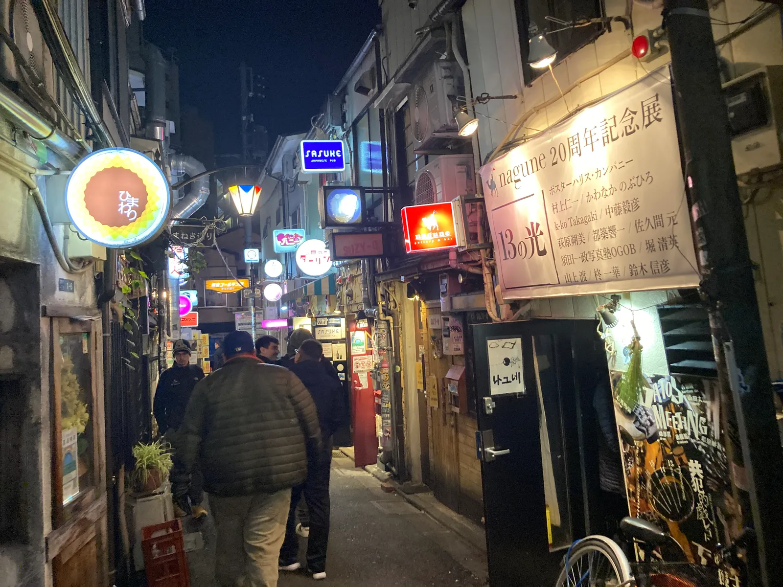 提灯とイルミネーションが下がる細い路地と鉄板焼きの店先
