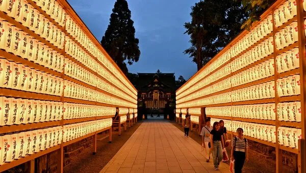 提灯がずらりと灯る参道を歩く人々