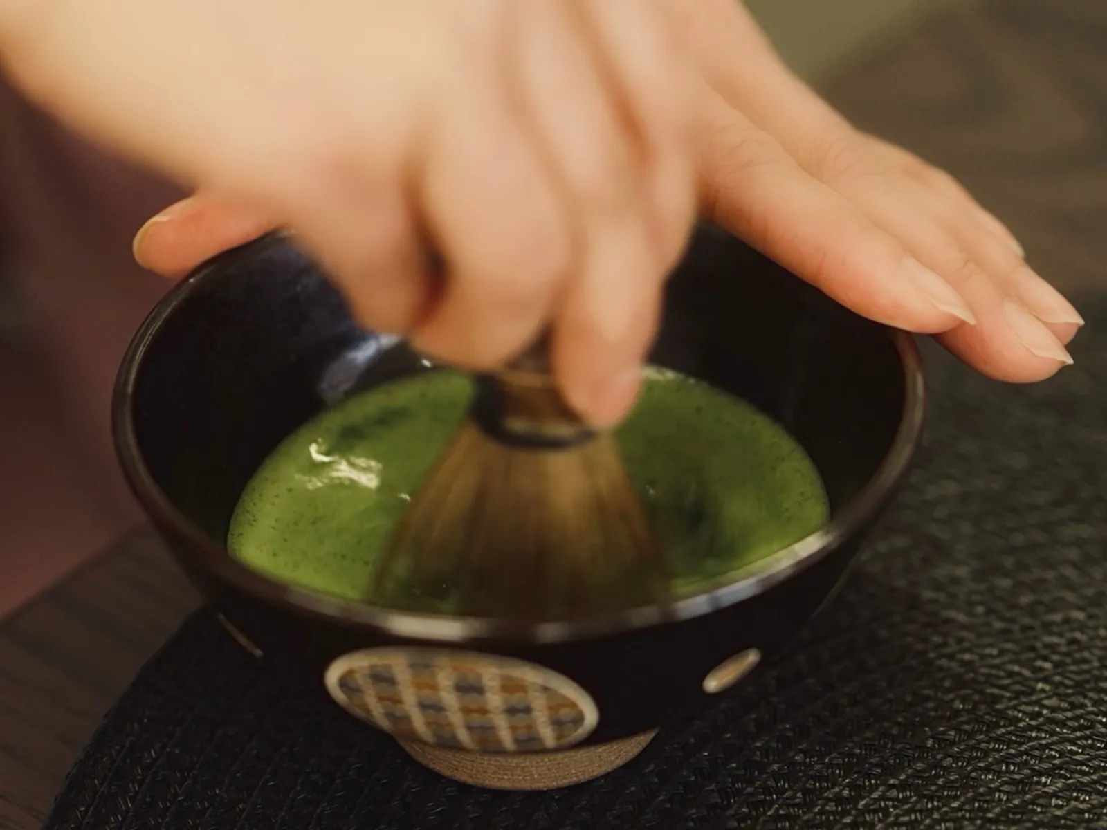 A tea bowl, bamboo whisk, tea scoop, tea caddy, waste-water bowl, and thermos arranged on a mat