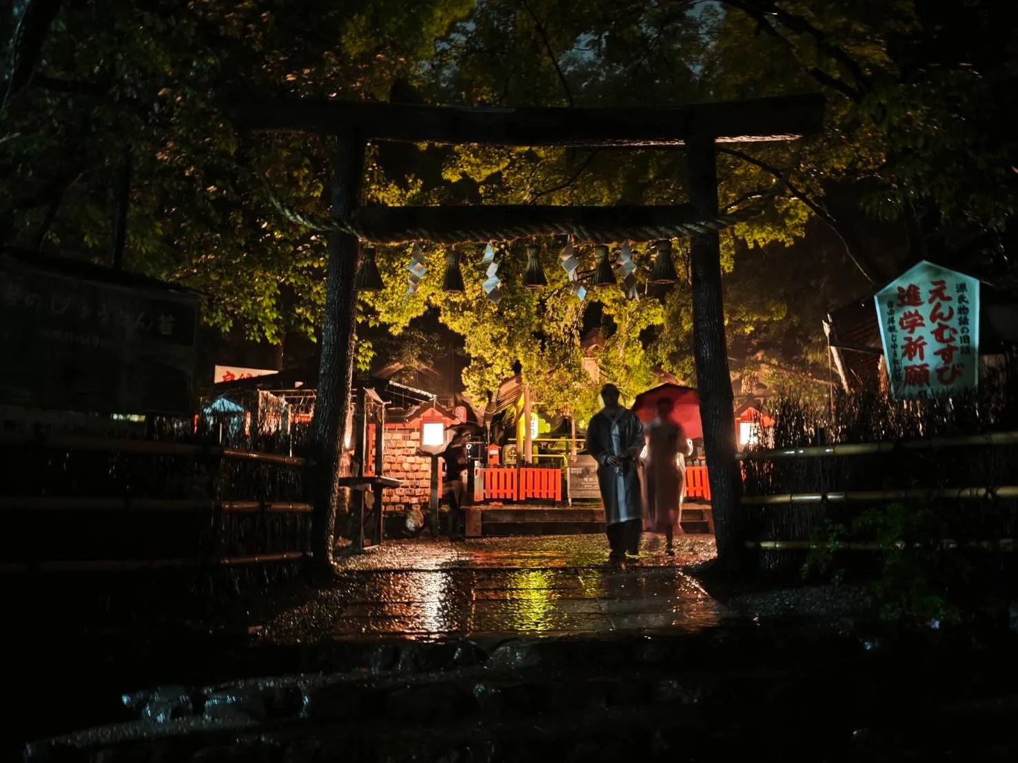 夜の京都でライトに照らされた鳥居と神社境内