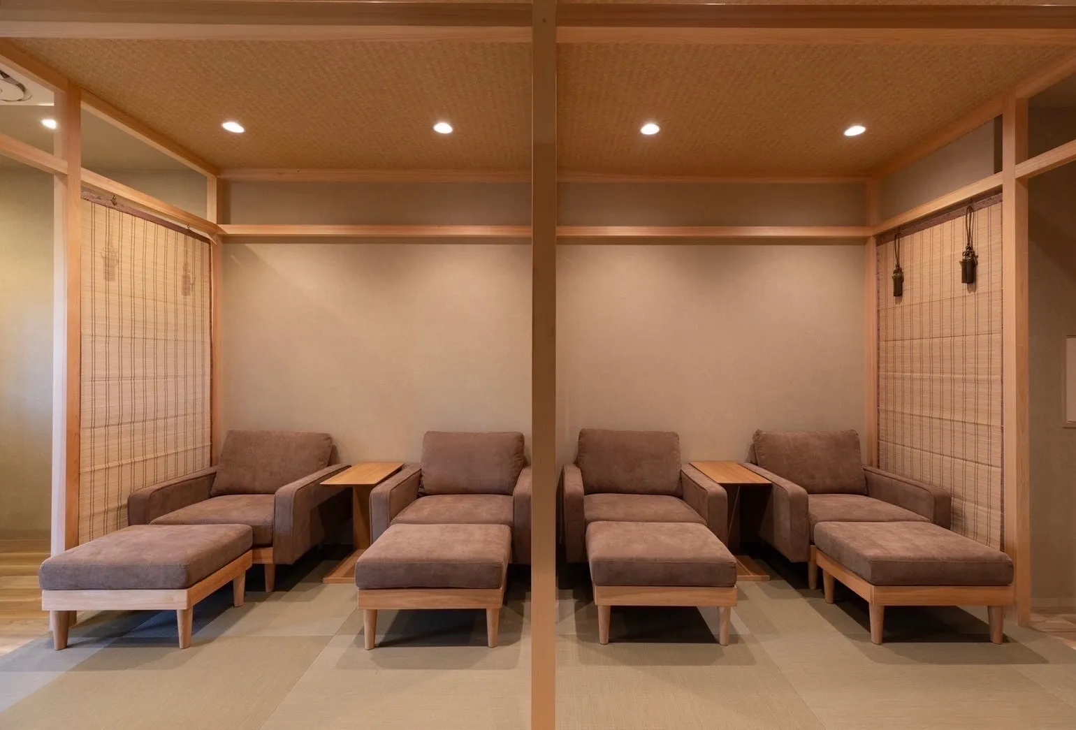 Four sofas with ottomans and side tables lined up in a tatami-floored space