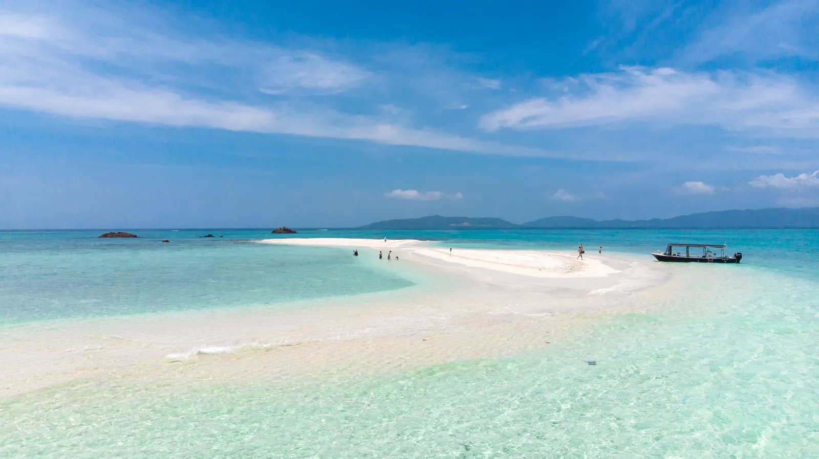 青い海に細長く延びる白い砂の島とボート