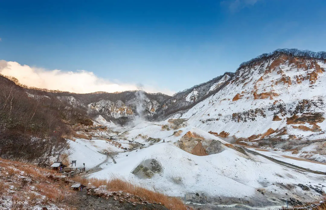 雪に覆われた登別地獄谷の全景と立ち上る湯けむり