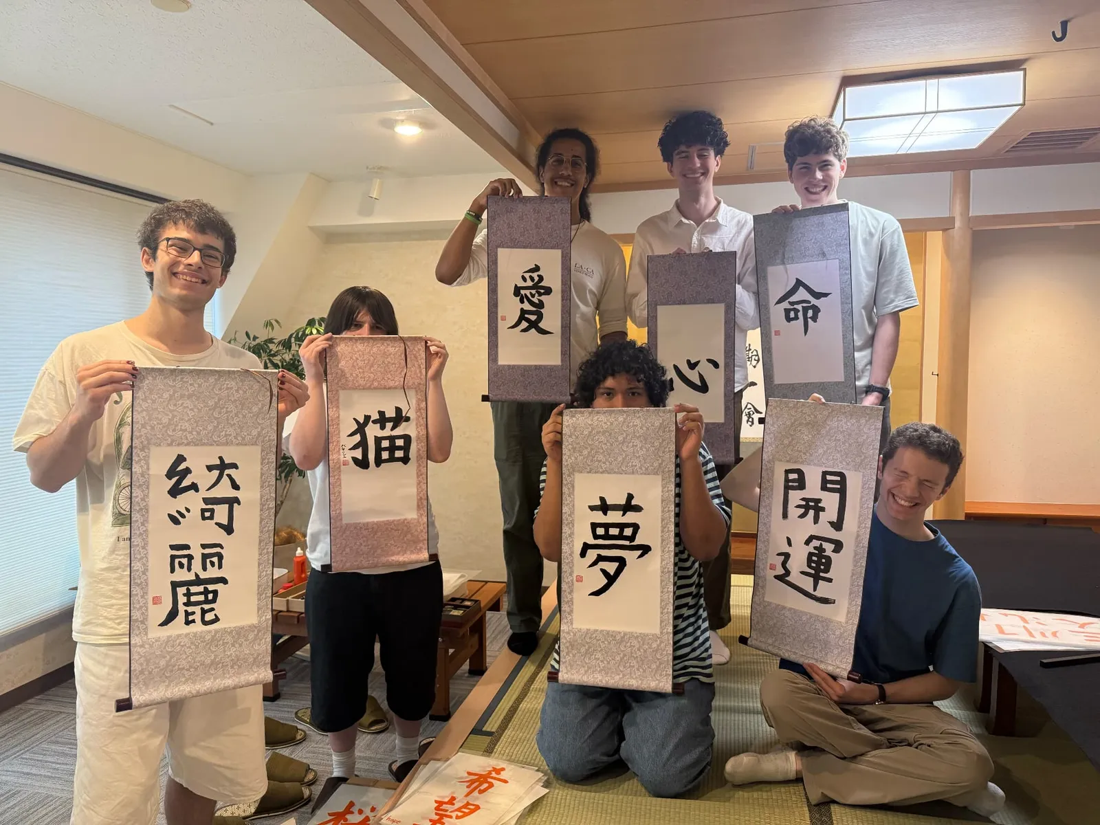 A group of participants holding up hanging scrolls