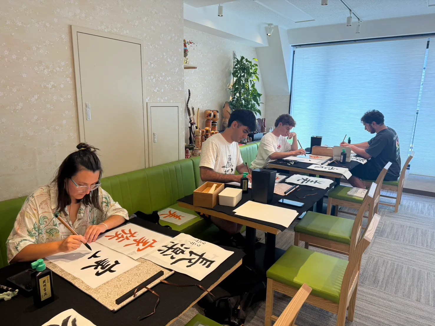 Participants sitting side by side at a table writing their pieces