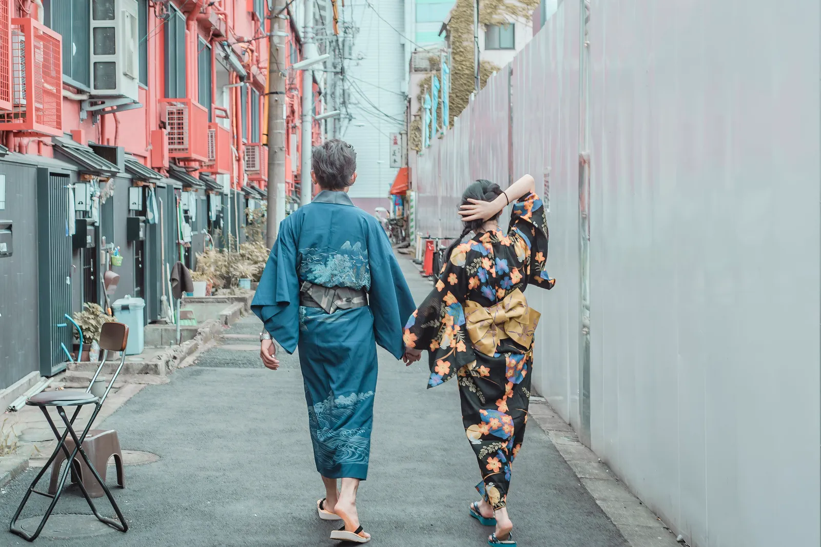 A couple walking away down a lane in Shita-Asakusa, wearing a floral-patterned kimono and a blue kimono