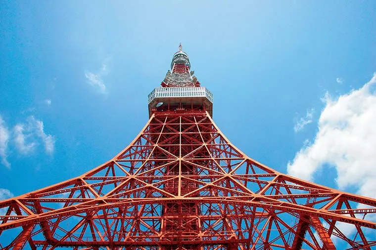 The steel frame of Tokyo Tower seen from directly below against a blue sky