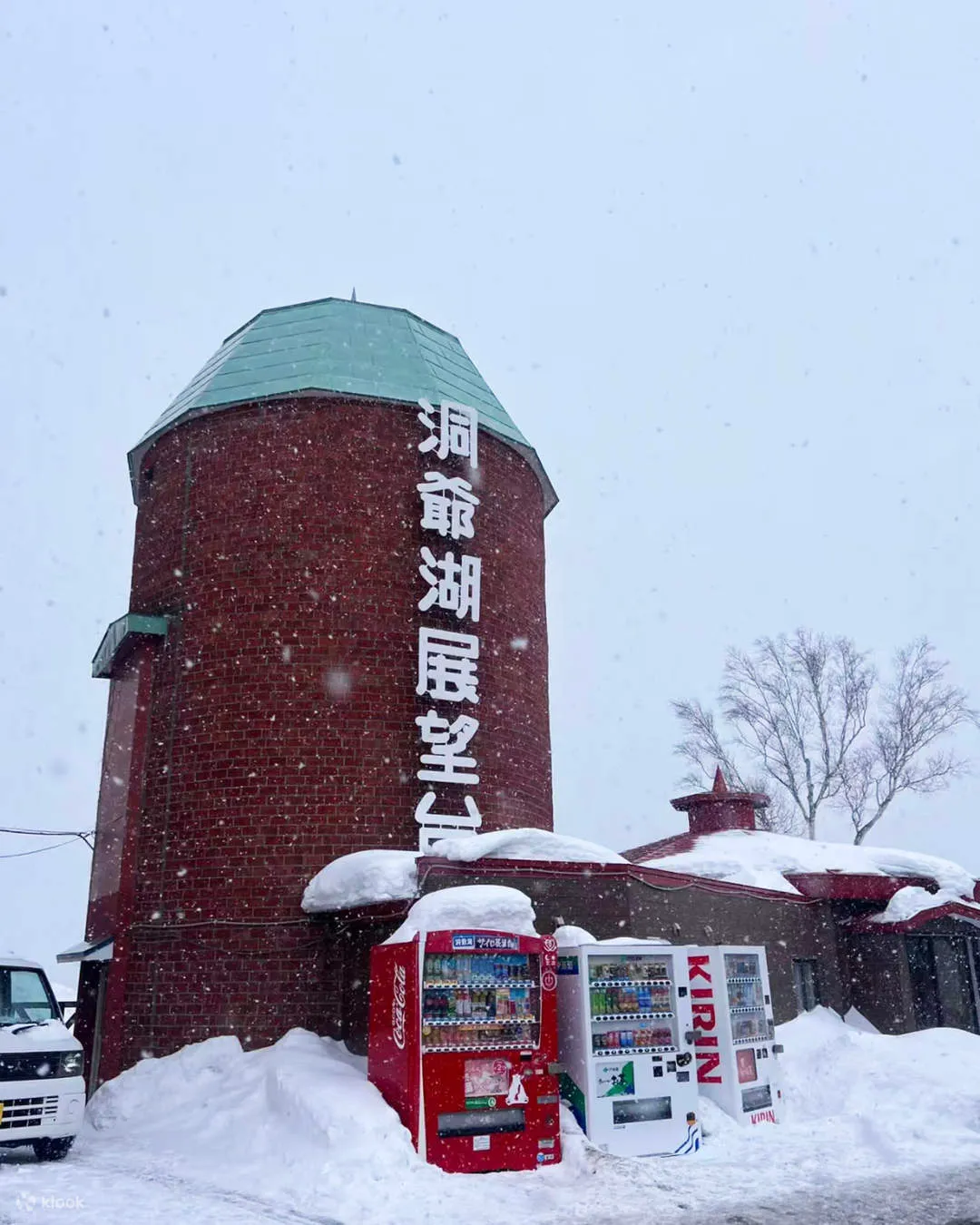 雪が降る中に立つ洞爺湖展望台のレンガ造りの塔